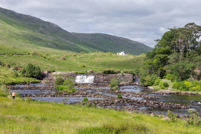 Aasleagh Falls cascading over rocks on the Erriff River with green hills in the background